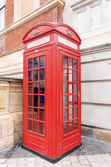Fototapeta premium London phone booth. An iconic red phone in London cabin in a city street