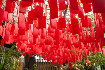 Colorful red paper decorations hanging from the ceiling in a temple for a celebration