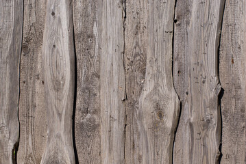 The old fence is made of old wooden boards. Texture of gray old wood very close up
