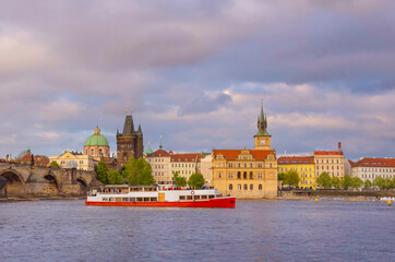 Fototapeta premium View of old town with Charles Bridge (Karluv Most) on Vltava river and Old Town Bridge Tower, famous tourist destination in Prague, Czech Republic (Czechia), at sunset