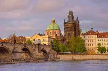 Obraz premium View of old town with Charles Bridge (Karluv Most) on Vltava river and Old Town Bridge Tower, famous tourist destination in Prague, Czech Republic (Czechia), at sunset