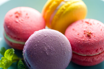 Colored macaroons. Delicious sweet colorful French desserts on light background