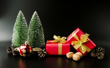 Christmas card, party invitation, New Year gifts and green Christmas trees on a black background.  Space for copying text, advertising.  Christmas and New Year holiday concept.