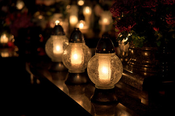 white spherical candles shining in the cemetery at night