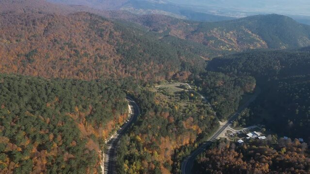Curvy mountain roads in autumn. Vehicles in motion on winding mountain roads. 