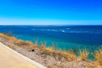 Fototapeta na wymiar Panoramic view of Sea of Cortez with blue waters with peninsula in background, seen from a tourist viewpoint on mountain, sunny spring day in La Paz, Baja California Sur Mexico