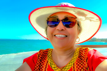 Face portrait of a beautiful happy smiling Mexican woman with hat, hair up, sunglasses and red...