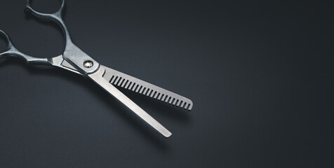 Professional Haircutting Scissors. Open hairdresser scissors on a black background. Professional tool for hairdressers scissors.