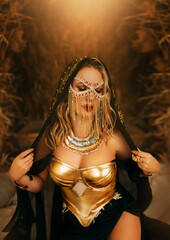 Art fantasy sexy arabic woman in black creative design dress. clothes gold accessories chain mask burqa hide beauty face. Oriental fashion model girl Bedouin queen. Sand sun divine magic light Egypt
