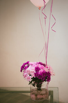 Bouget of fresh flowers on a table and decorative balloons.