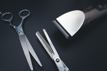 Barbershop concept.Hairdressing scissors and Machine for a hairstyle on black background. Hair extensions, materials and cosmetics, hair care, wig. Hairstyle, haircut in salon.