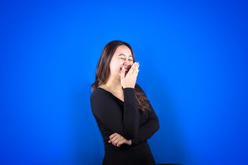 Portrait of a happy Asian woman smiling with her mouth covered