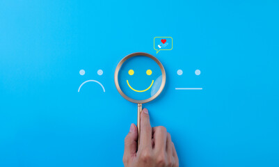 Mental Health Day concept. Magnifying glass help see a smiley face icon that depicts happy and...