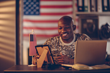Smiling soldier looking at picture frame at base