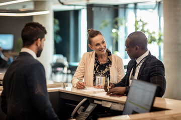 Receptionist Assisting Business Clients at a Hotel Lobby