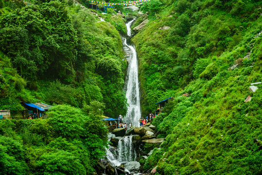 Majestic landscape of Bhagsu Nag waterfall and green forest around at Mcleodganj, Himachal Pradesh, India.