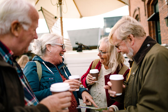 Group of elderly friends enjoying coffee together outdoors