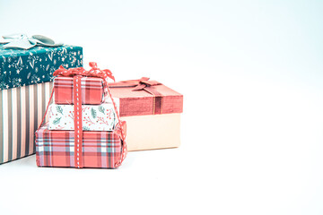 Three gift boxes with ribbon bows and Christmas tree branch on white background.