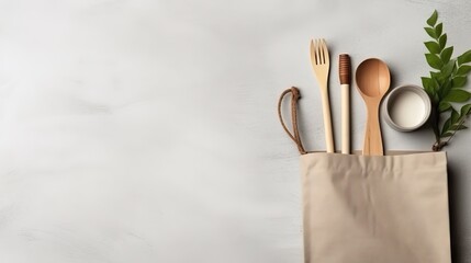 Cotton shopping bag, bamboo cup, metal drinking straws, wooden coconut cutlery and bowl on grey...