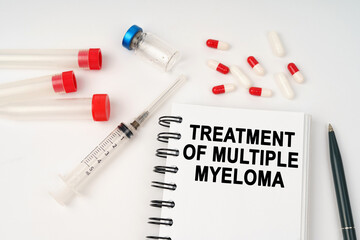 On the table are pills, injections, a syringe and a notepad with the inscription - treatment of multiple myeloma