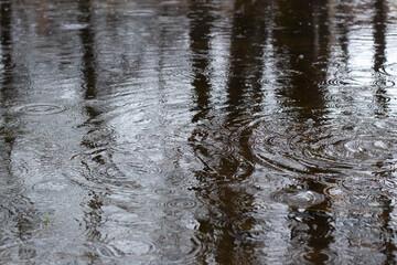 Rain outside. Texture of water. Circles on water.