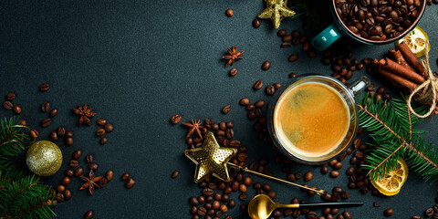 A cup of coffee on a table with New Year and Christmas decorations. Top view, on a black...