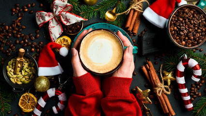 Cappuccino, hot chocolate latte coffee with Merry christmas drawing  on warm wooden background, Christmas winter cozy cup with hot chocolate drink in woman hands, top view copy space