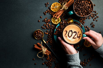 Cup of cappuccino with cinnamon. New Year's decor. Numbers 2024. On a dark background.