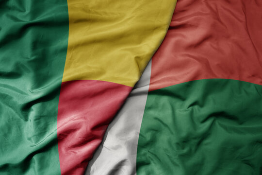 big waving national colorful flag of benin and national flag of madagascar .