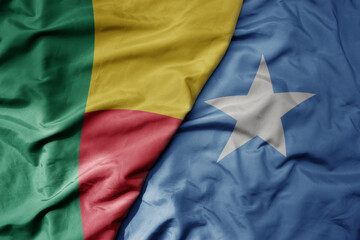 big waving national colorful flag of benin and national flag of somalia .