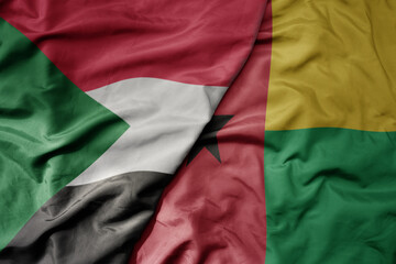 Obraz premium big waving national colorful flag of sudan and national flag of guinea bissau .