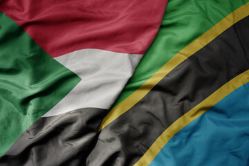 Obraz premium big waving national colorful flag of sudan and national flag of tanzania