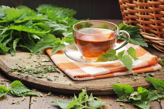 Nettle leaf tea with fresh green leaves on wooden rustic table, closeup, copy space, natural medicine, diet food and drink, homeoparhy, hair and skin healthy care, detox and diet healthy food concept