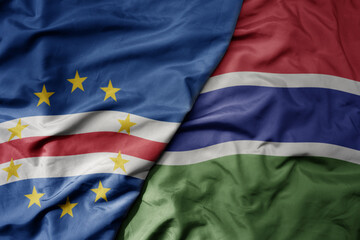 Fototapeta premium big waving national colorful flag of cape verde and national flag of gambia .