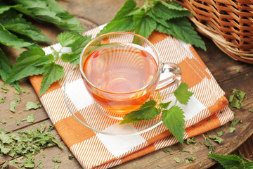 Nettle leaf tea with fresh green leaves on wooden rustic table, closeup, copy space, natural...