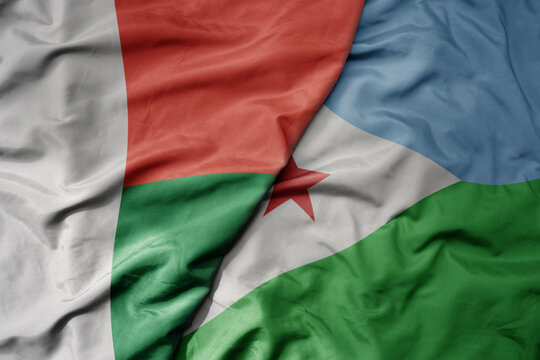 big waving national colorful flag of madagascar and national flag of djibouti .