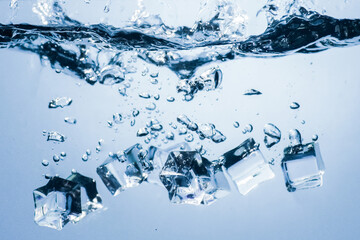 ice cubes falling down. ice cubes on blue background. splash on blue. ice cubes in water