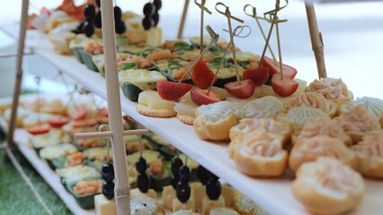 Catering on a banquet table with appetizers-canapes in a restaurant or hotel. Snacks on the table, catering concept. buffet food set for corporate day celebration.