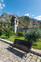 Bench in front of bell tower of Saint Clare church in old town of Kotor, Montenegro.