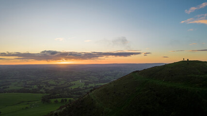 The sun rises over the Skirrid Fawr mountain near Abergavenny in the Brecon Beacons Black Mountains national park. morning walkers enjoy rugged natural beauty in Bannau Brycheiniog South Wales