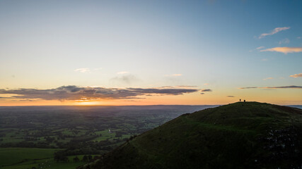 The sun rises over the Skirrid Fawr mountain near Abergavenny in the Brecon Beacons Black Mountains national park. morning walkers enjoy rugged natural beauty in Bannau Brycheiniog South Wales