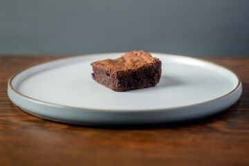 A piece of dark chocolate brownie on the table.