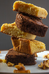 A tower of some pieces of brownies of white and dark chocolate.