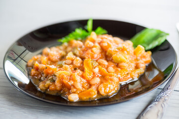 Cooked white beans with zucchini and other vegetables.