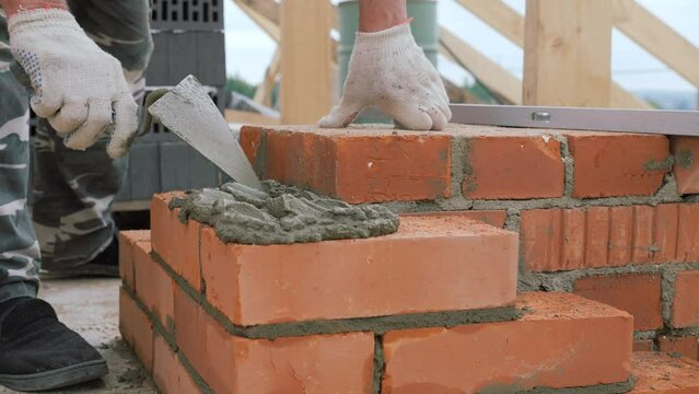 Laying out a brick chimney chimney of a private wooden house.