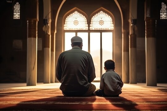 Muslim father and his son pray the koran in a mosque