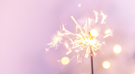 Beautiful sparkles from sparklers on the background of New Year's bokeh, Christmas mood, glitter, festive background.