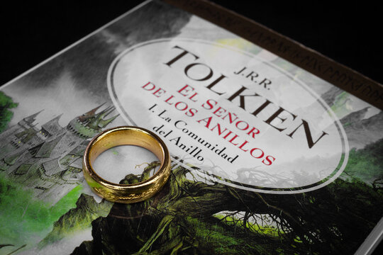 Closeup to a Ring of power of lord of the rings history over the lord of the rings the fellowship of the ring text book front page in spanish