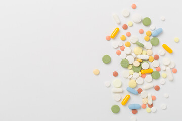 Different medical pills and capsules on color background, top view