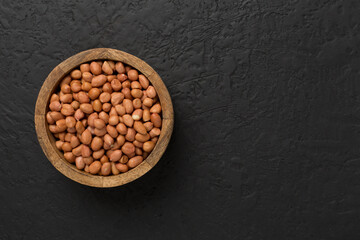 Peeled peanuts on concrete background, top view